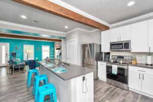 uma cozinha com armários brancos e paredes azuis em Prolific Blue Oasis near Med Ctr Dwntwn Galleria em Houston