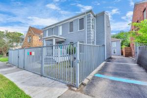 uma casa cinzenta com uma cerca na entrada da garagem em Prolific Blue Oasis near Med Ctr Dwntwn Galleria em Houston