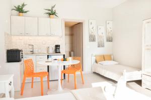 kuchnia i salon ze stołem i krzesłami w obiekcie Louiza Apartments w mieście Agios Gordios