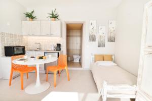 a small kitchen with a table and chairs and a couch at Louiza Apartments in Agios Gordios