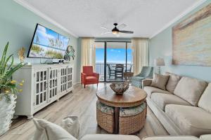 een woonkamer met een bank en een tafel bij Summer House 1402A in Orange Beach