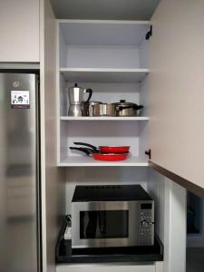 a kitchen with a microwave and some pots and pans at Apartamento Medina cerca de la Ribera in Córdoba