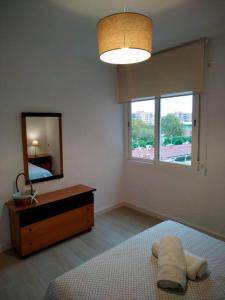 a bedroom with a bed and a dresser and a mirror at Apartamento Medina cerca de la Ribera in Córdoba