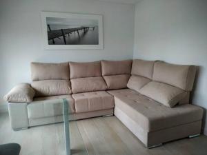 a brown couch in a living room with a table at Apartamento Medina cerca de la Ribera in Córdoba