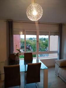 a living room with a table and chairs and a large window at Apartamento Medina cerca de la Ribera in Córdoba