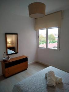 a bedroom with a bed and a dresser and a mirror at Apartamento Medina cerca de la Ribera in Córdoba