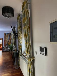 a living room with a yellow curtain and a tv at Apartament w centrum Brzeska in Brzesko