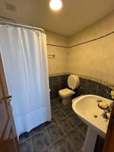 y baño con cortina de ducha blanca y aseo. en Hermoso depto, inmejorable zona! en Santa Rosa