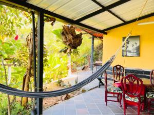 eine Hängematte auf einer Terrasse mit einem Tisch und Stühlen in der Unterkunft Refugio en el bosque in Barbosa