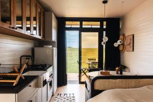 uma cozinha com um fogão e uma mesa num quarto em Tiny House Purunã - Refúgio Inspirador em Balsa Nova