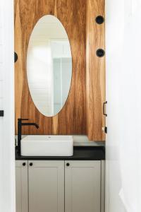 a bathroom with a sink and a mirror at Tiny House Purunã - Refúgio Inspirador in Balsa Nova