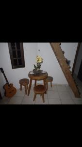 ein Tisch und Stühle mit einer Blumenvase drauf in der Unterkunft Casa Itamambuca in Ubatuba