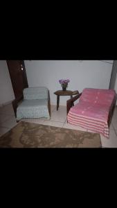 ein Wohnzimmer mit zwei Betten und einem Tisch in der Unterkunft Casa Itamambuca in Ubatuba