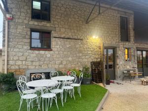 a table and chairs in front of a stone building at La Grange de Witry in Witry-lès-Reims