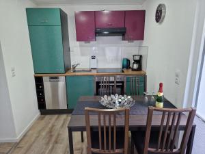 a kitchen with a table with two chairs and a kitchen with purple cabinets at Ferienhaus Gisela Arendsee in Arendsee