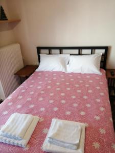 uma cama com duas toalhas em cima em Dimitris em Trikala