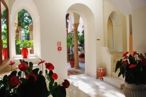 a hallway with red flowers in a vase at Hotel Villa Fraulo in Ravello