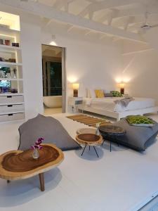 Sala de estar con 1 cama y 2 mesas en The Headland Villa 2, Samui, en Koh Samui 