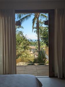 馬尊特的住宿－YAM HOTEL，卧室设有可欣赏棕榈树美景的窗户。