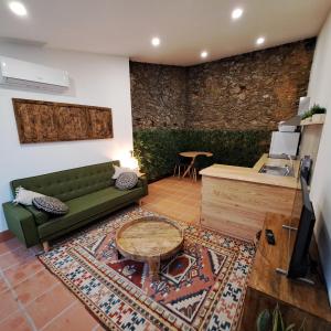 - un salon avec un canapé vert et une table dans l'établissement Quinta de Matrena, à Macieiros