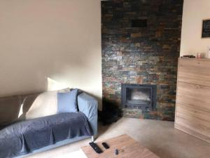 uma sala de estar com um sofá e uma lareira de tijolos em MAISON DE FAMILLE À 20 MN DE LISBONNE ET SETÚBAL em Quinta do Conde