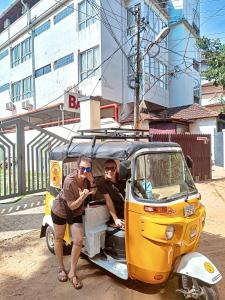 dos personas sentadas en la parte trasera de un coche pequeño en Santa Maria Hostel, Fort Kochi, en Kochi