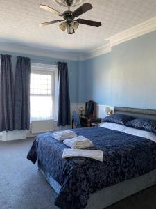 a bedroom with a bed and a ceiling fan at The Winchester in Great Yarmouth