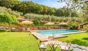 a swimming pool in a yard with chairs and umbrellas at Agriturismo Poggio Tondo in Monsummano Terme