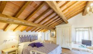 sypialnia z łóżkiem w pokoju z drewnianym sufitem w obiekcie Agriturismo Poggio Tondo w mieście Monsummano Terme