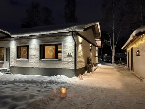 a house is covered in snow at night at Villa Kataja in Rovaniemi