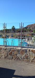 a large swimming pool with a stone wall at Villa Tauro Topaz in Mogán