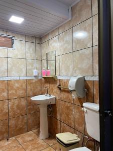 y baño con aseo y lavamanos. en Residencial Arcoiris en Puerto Iguazú