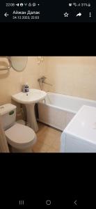 Однокомнатная квартира в Караганде في كاراغاندي: حمام مع مرحاض ومغسلة وحوض استحمام