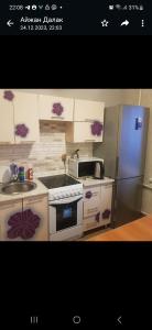 uma cozinha com um fogão e um frigorífico em Однокомнатная квартира в Караганде em Karaganda