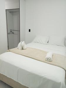 a bedroom with a white bed with towels on it at perla del norte in Bello