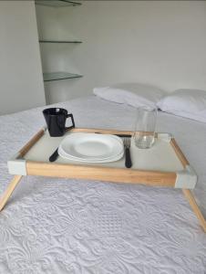 a tray with a plate and a glass on a bed at Flat Beira Mar Terrazzas in João Pessoa