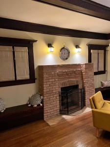 a living room with a brick fireplace with a clock on the wall at Historical Retreat in Los Angeles