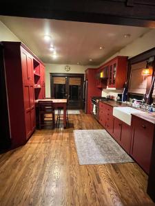 Il comprend une cuisine avec des placards rouges et du parquet. dans l'établissement Historical Retreat, à Los Angeles
