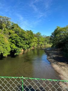 a river with trees and a fence in the foreground at Finkita Nosara House R in Nosara