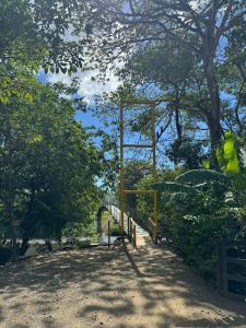 un parco giochi in un parco con panchina e alberi di Finkita Nosara House R a Nosara