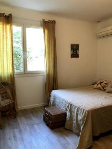 een slaapkamer met een bed en een raam bij Maison au coeur de la Provence in Jonquerettes