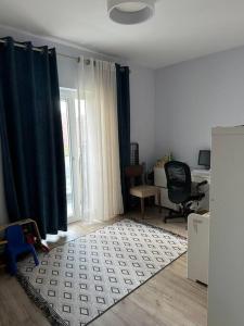 soggiorno con tenda blu e scrivania di Eden Apartment: 2BR, Family friendly a Tirana