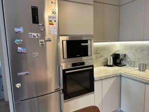 ティラナにあるEden Central Apartment - Modern 2BR in Tirana City Centerのキッチン(ステンレス製の冷蔵庫、電子レンジ付) +2枚の写真