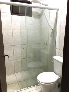 La salle de bains est pourvue d'une douche en verre et de toilettes. dans l'établissement Estância Colibri, à Parati