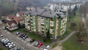 an apartment building with cars parked in a parking lot at Apartman N&D in Banja Luka