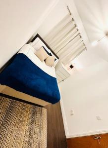 um quarto com uma cama com lençóis e almofadas azuis em Kilburn Hideaway Family and Pet-Friendly Apartment in Cosmopolitan Locale em Londres