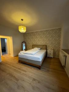 a bedroom with a bed and a chandelier at Paris bei Düsseldorf in Hilden