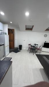 uma cozinha e sala de estar com mesa e cadeiras em Kilburn Hideaway Family and Pet-Friendly Apartment in Cosmopolitan Locale em Londres