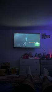 a person laying on a bed watching a tv at Poama villa in Negruleşti