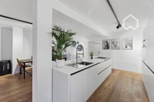 a white kitchen with white cabinets and a sink at Day Young Life/DYLHosting 130qm Pool/Garten/Parkpl in Nürnberg